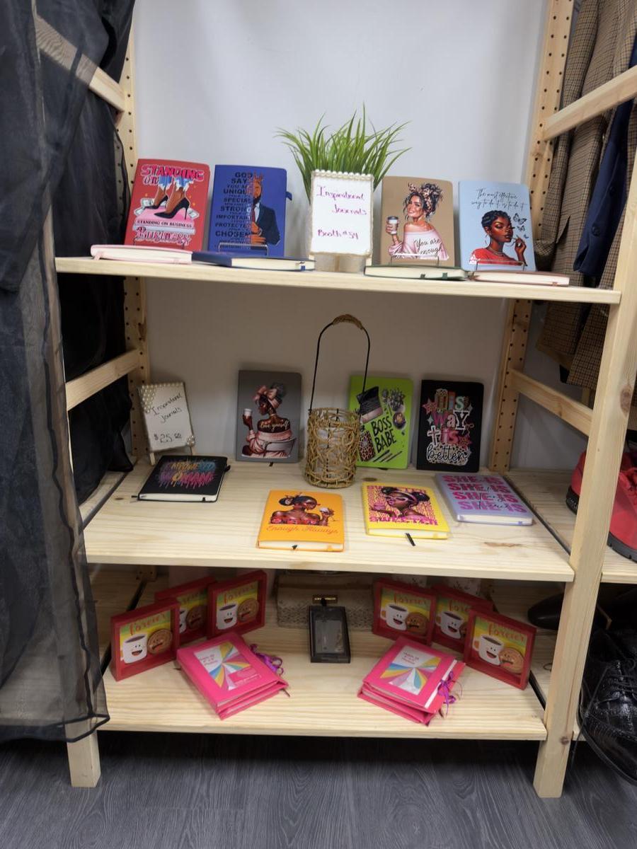 Shelf of books, journals, and curated gifts from local makers