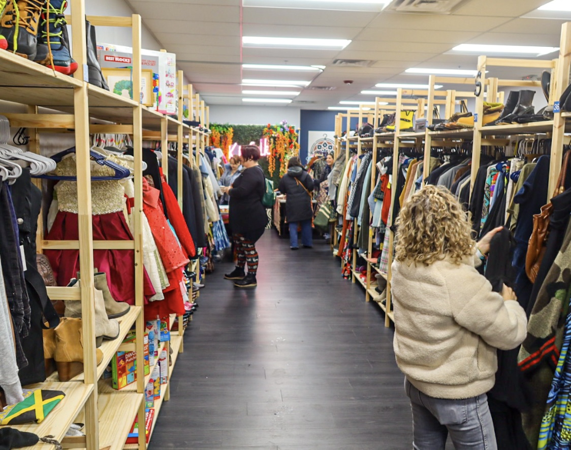 Shoppers browsing the open aisles and wood shelving inside Kinfolk Marketplace